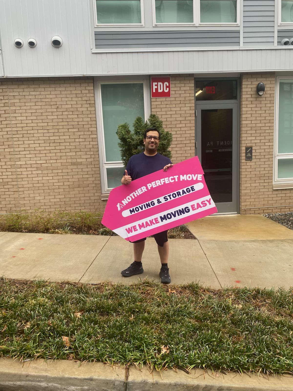 Happy Another Perfect Move customer holding a branded sign