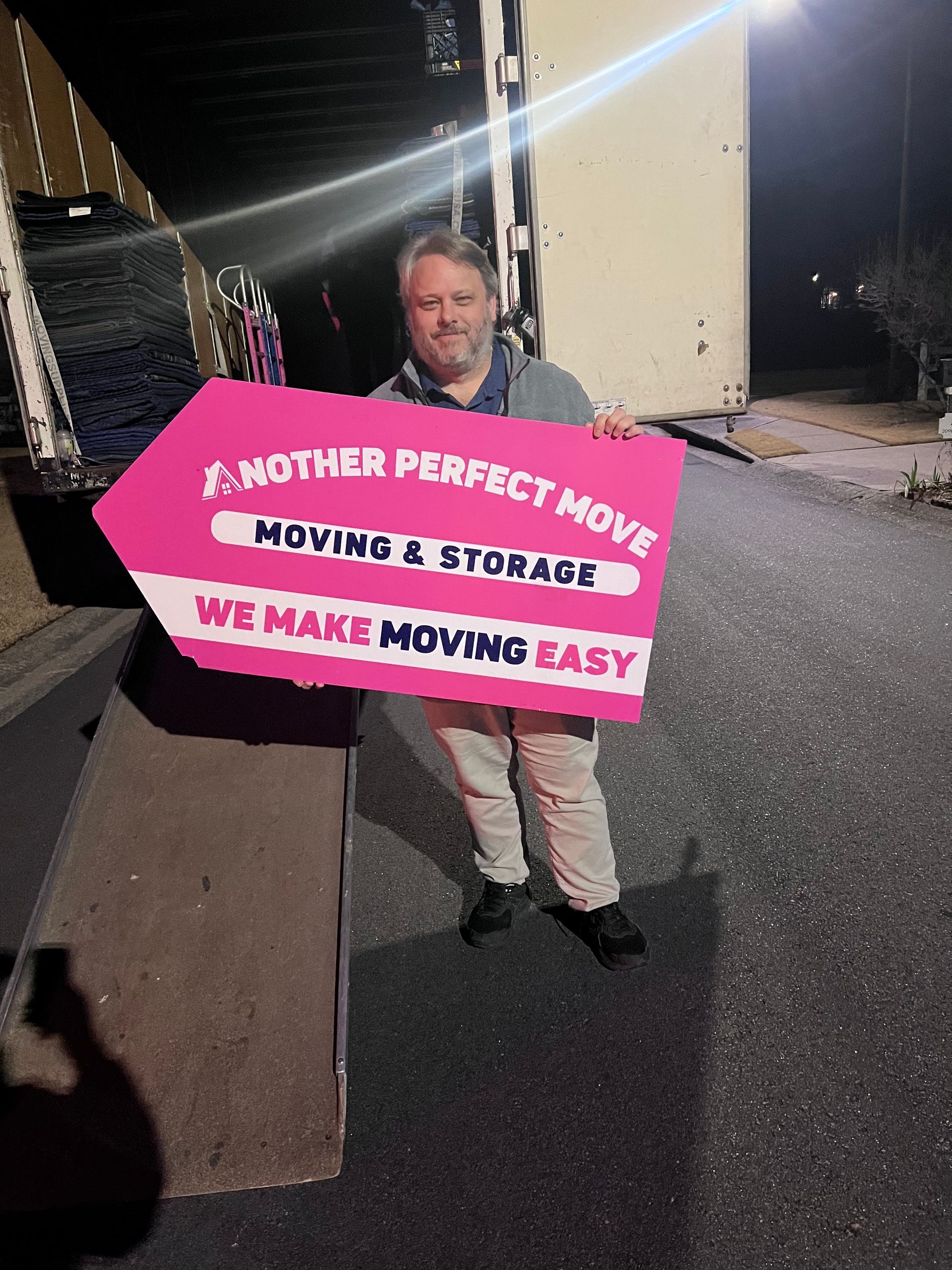 Happy client holding an Another Perfect Move moving sign