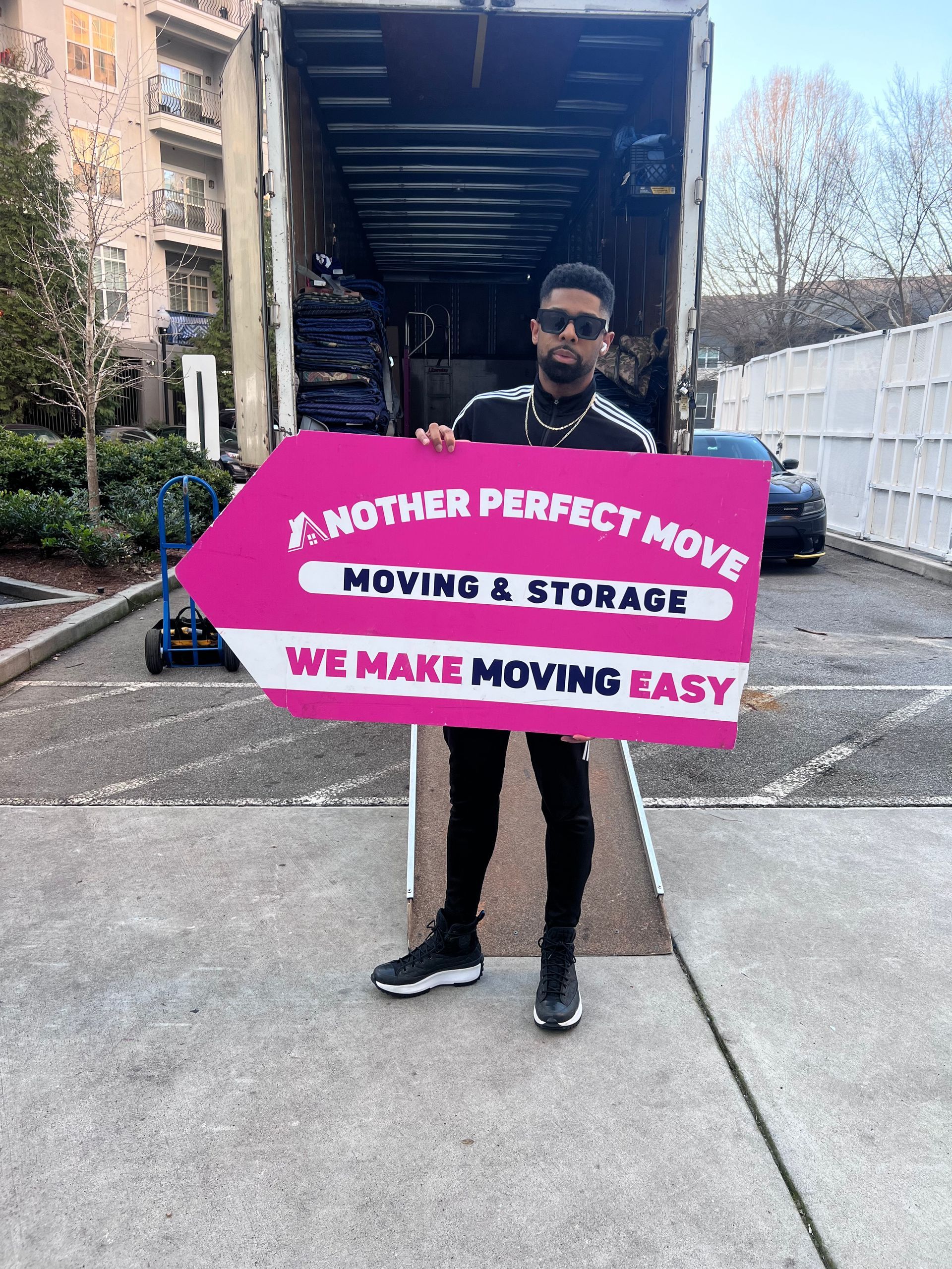Smiling customer with an Another Perfect Move branded sign